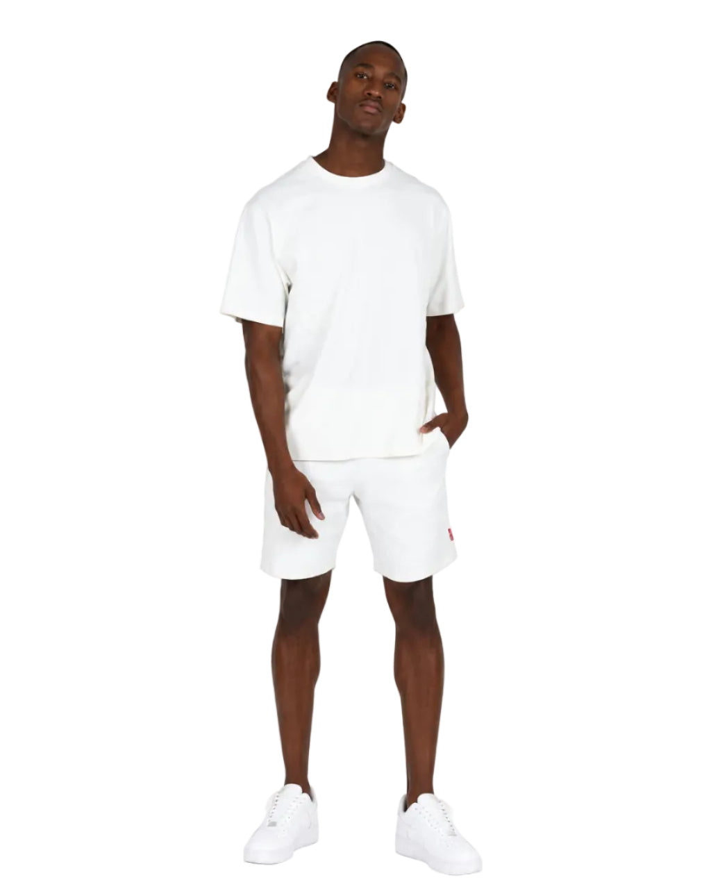 A man modeling a white crew-neck t-shirt and matching white shorts against a plain white background.