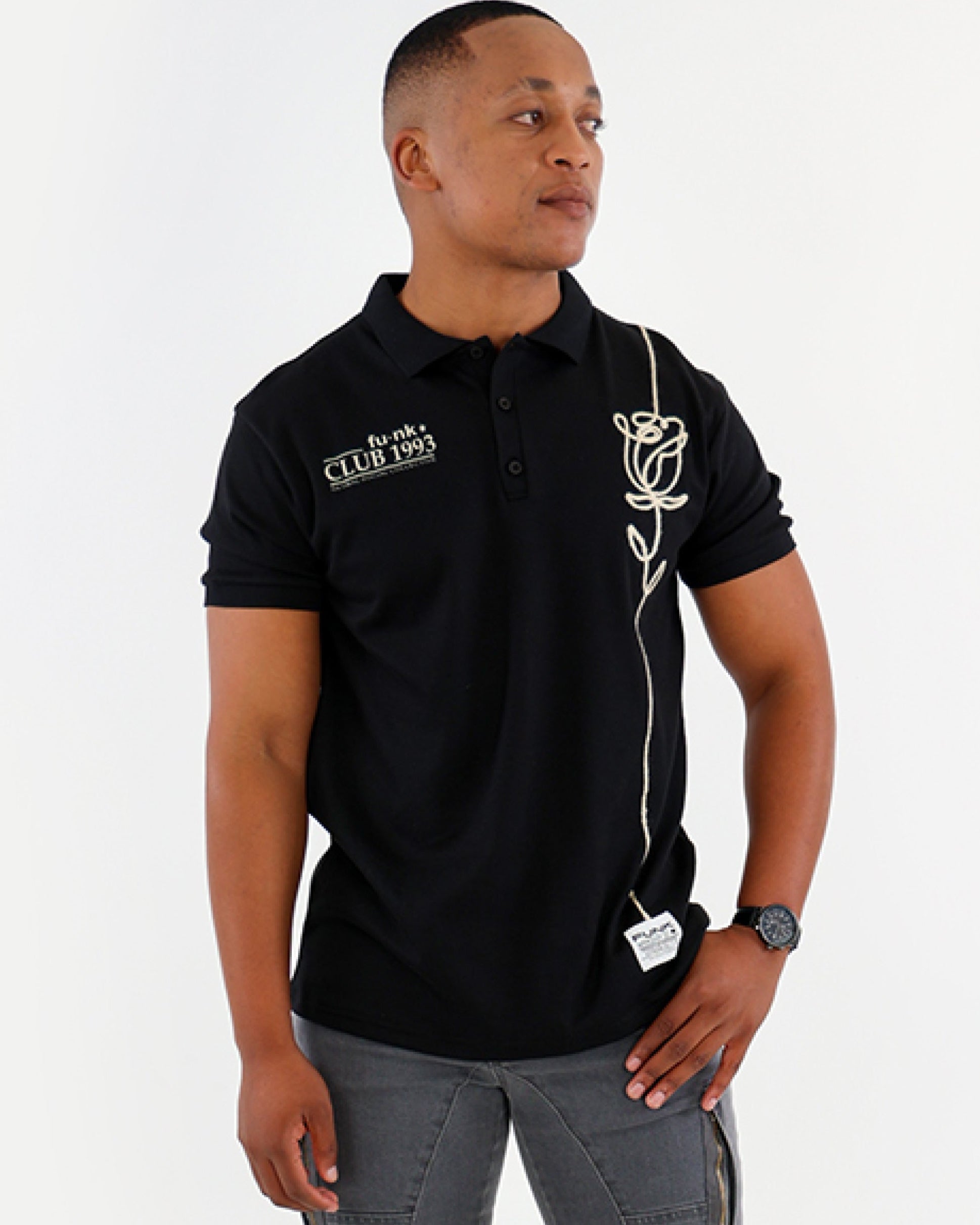 Man wearing a black polo shirt and gray pants on a white background