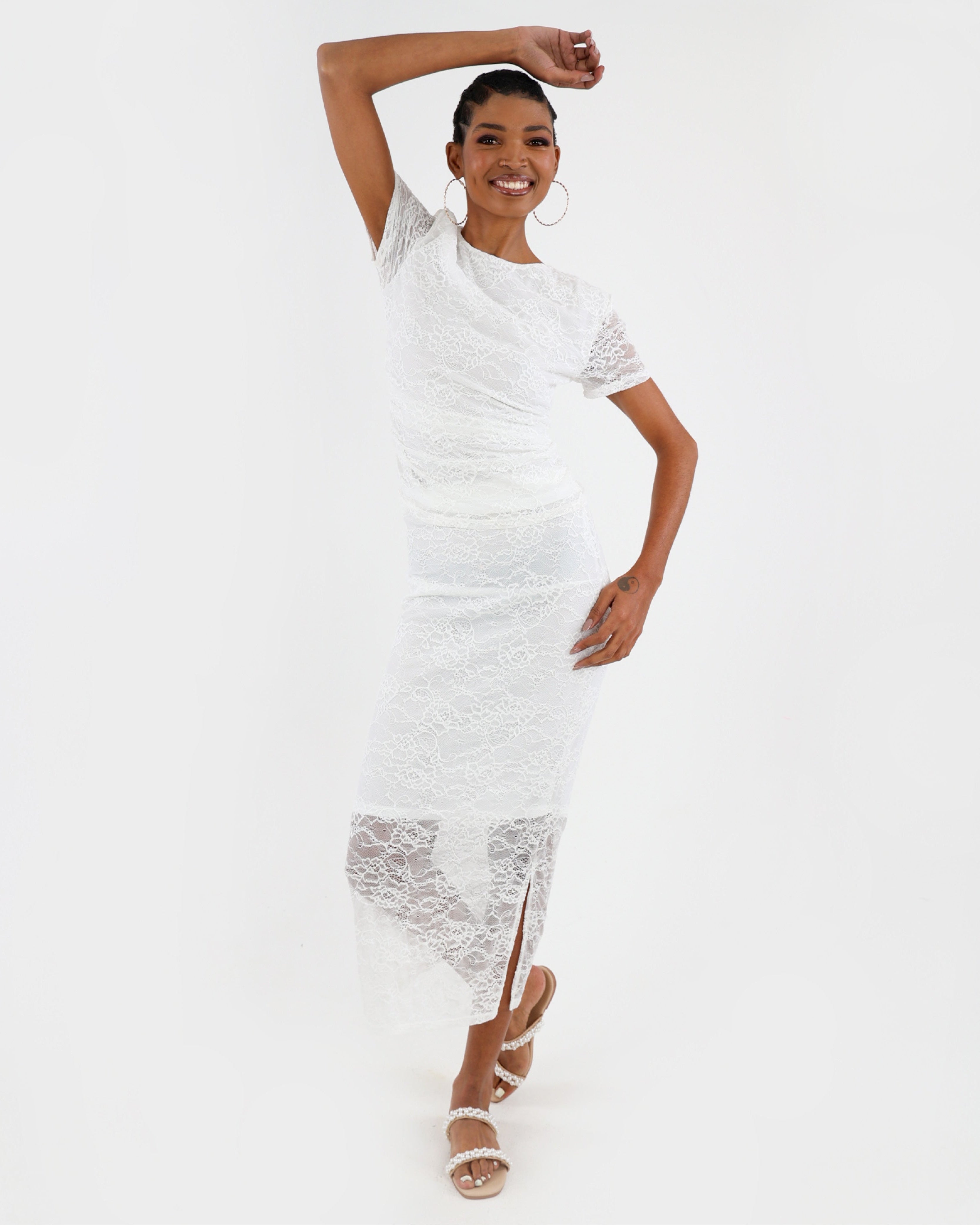 Woman wearing a white lace dress on a white background